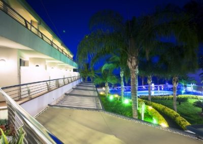 Vista de noche al jardín y piscina del hotel